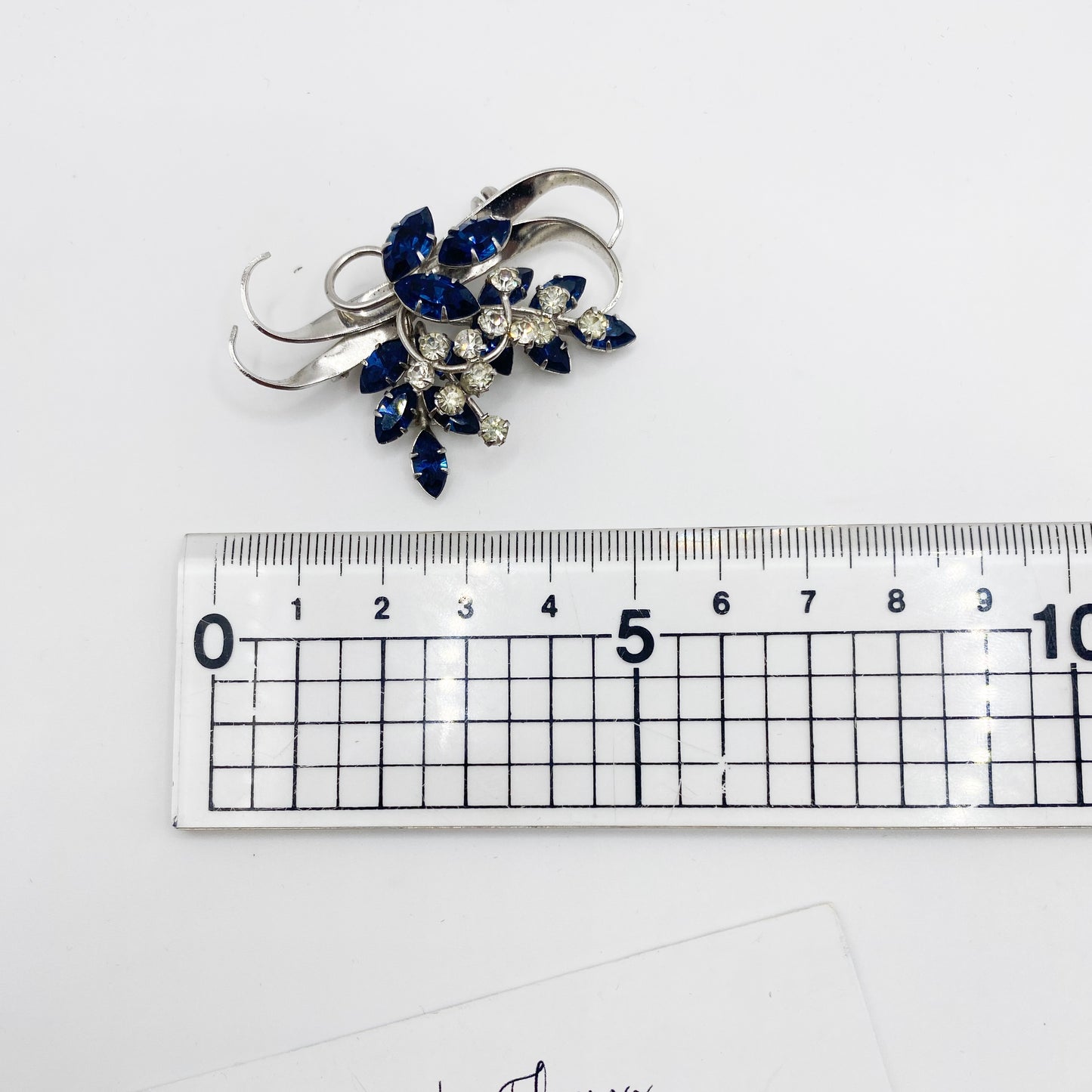 1940s Jewelcrest brooch placed next to ruler for scale.