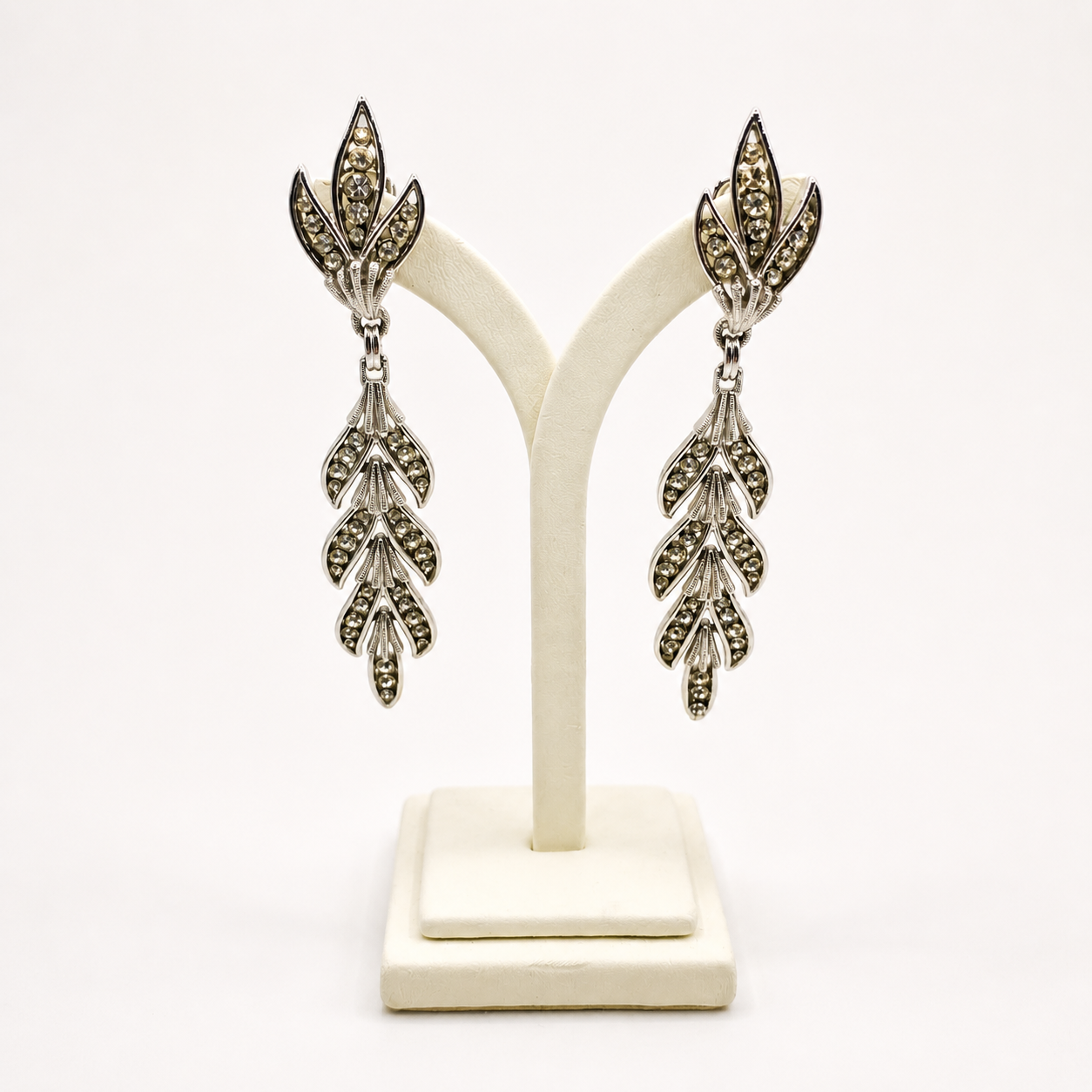 A pair of 1950s Trifari earrings on a jewellery stand. 