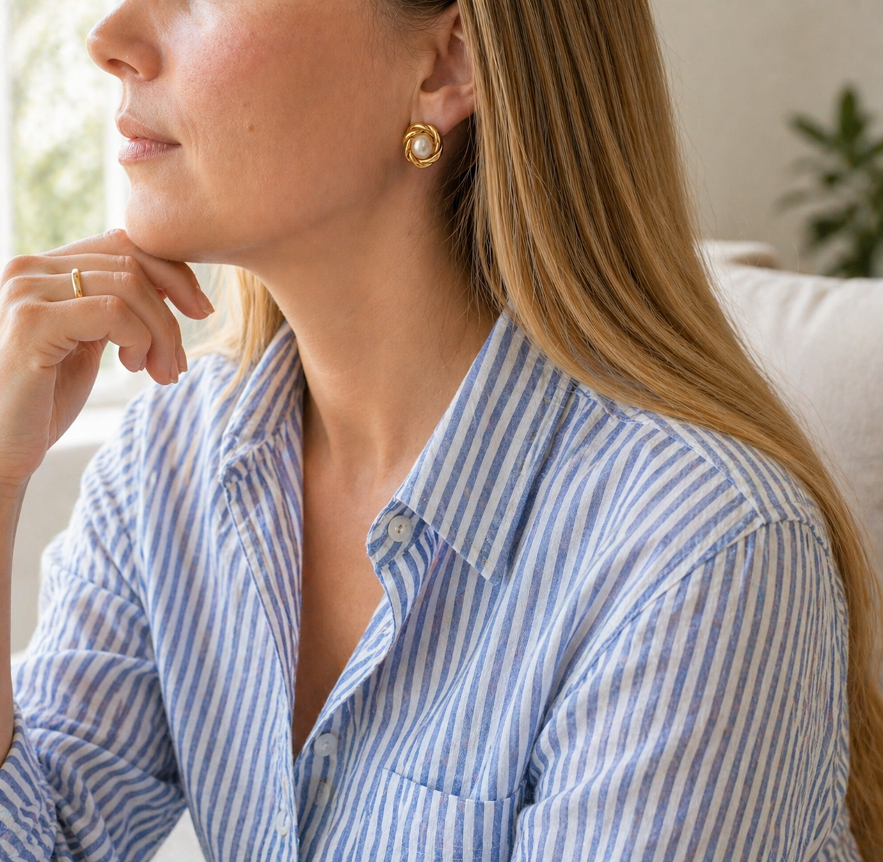1980s Gilt knot pearl earrings, styled on a model wearing a linen shirt. 