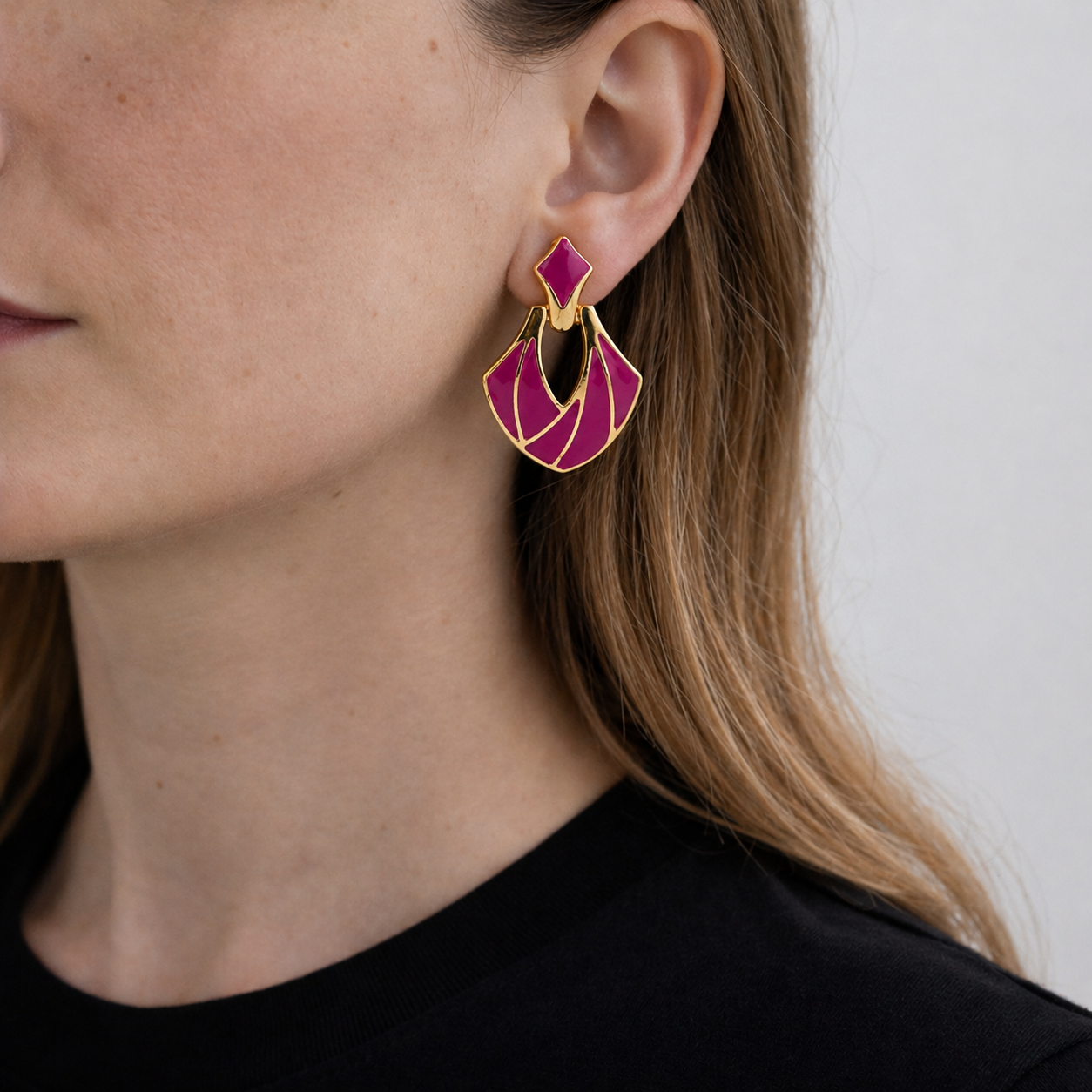 Vintage 1980s Deco Style Magenta Earrings, styled on a model with a black knit. 