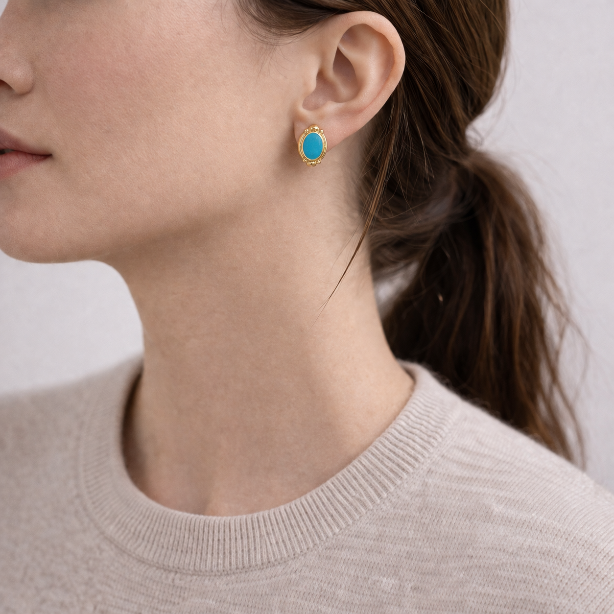 1990s Turquoise and gilt earrings for pierced ears, styled on model. 