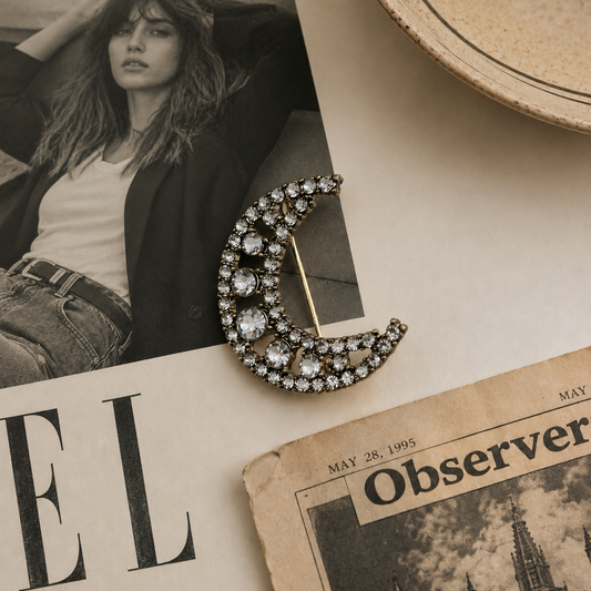 Vintage 90s Crescent Moon Brooch, on a table with a newspaper and magazine 