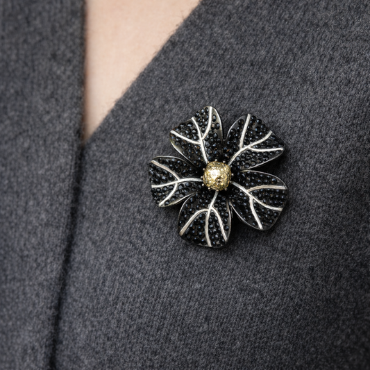 Style shot of the vintage Napier black crystal flower brooch on grey knit. 