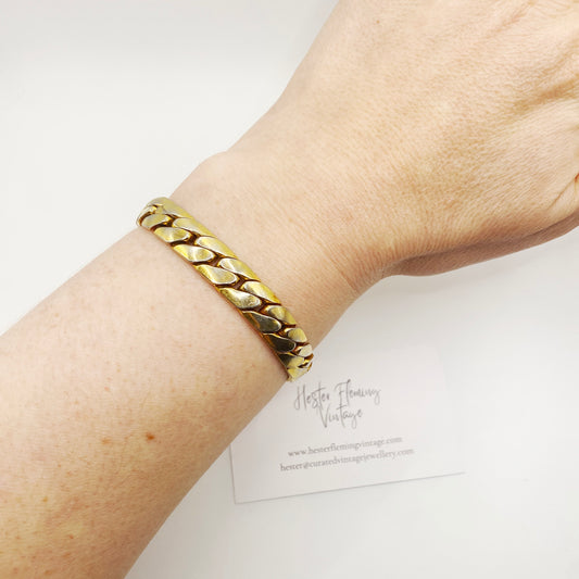 Wrist view of an authentic signed Christian Dior 1970s gold link bracelet