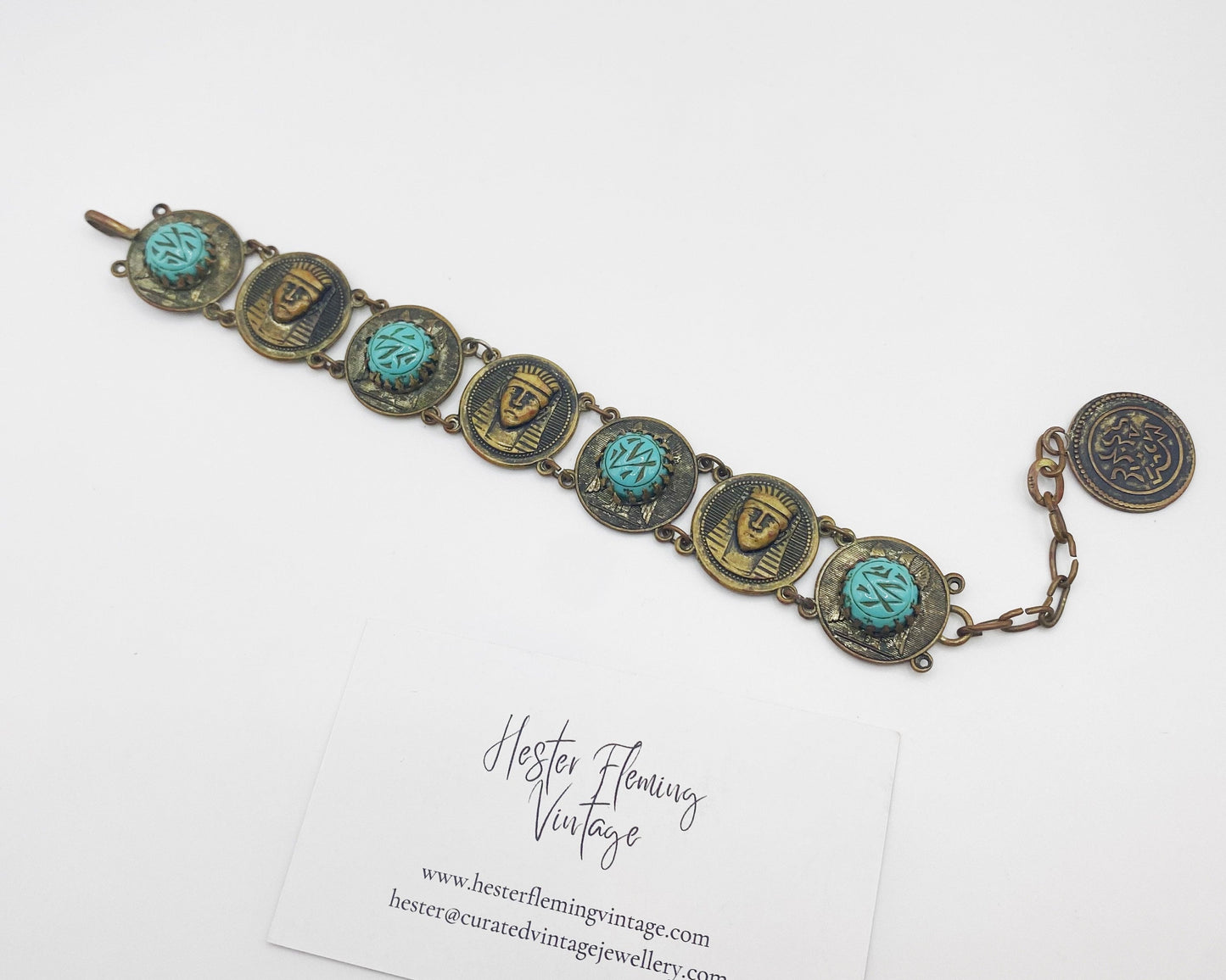 Full-length image of 22cm antique Egyptian Revival turquoise and brass bracelet laid flat.