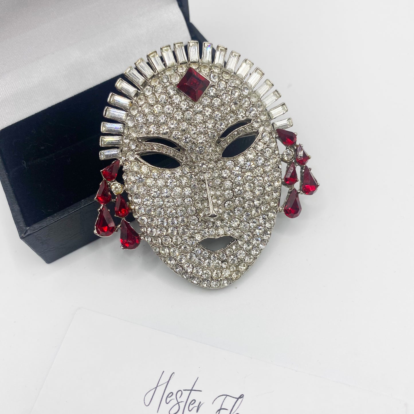 1990s Butler and Wilson masquerade mask brooch with clear rhinestones and red crystal drops