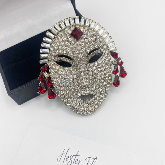 1990s Butler and Wilson masquerade mask brooch with clear rhinestones and red crystal drops