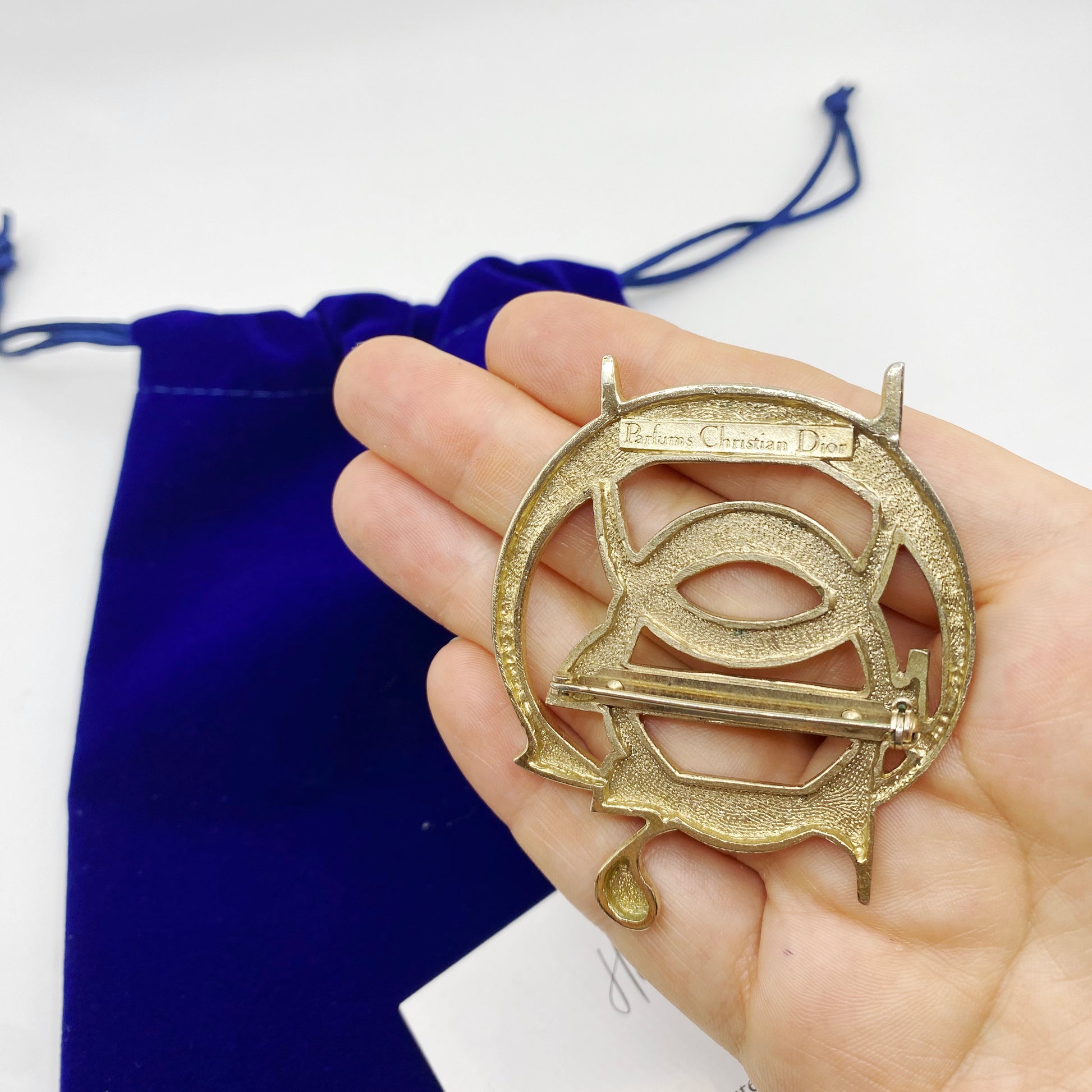 Back of vintage Christian Dior brooch signed Parfums Christian Dior showing clasp and patina