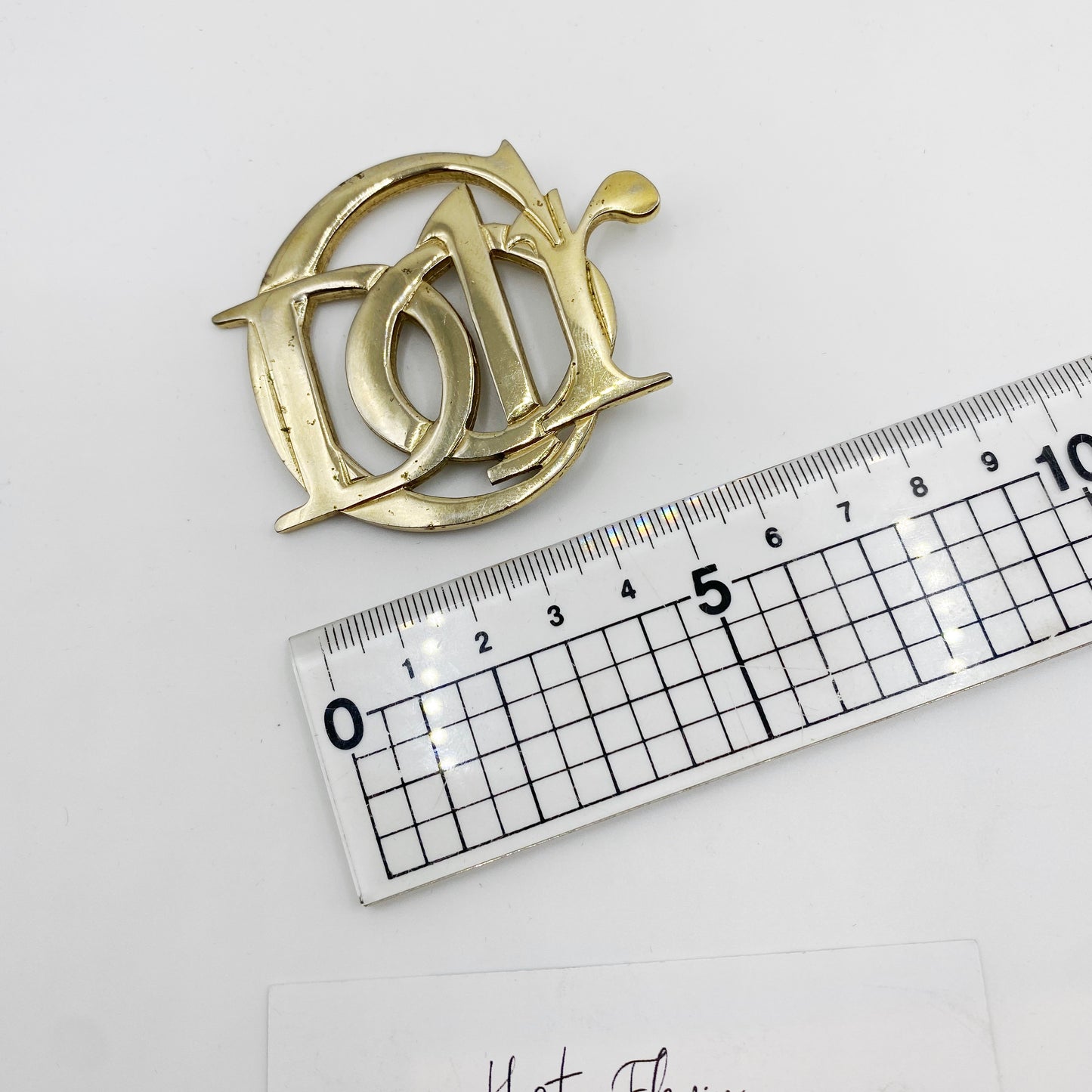 Vintage Christian Dior CD monogram brooch shown beside ruler for size reference