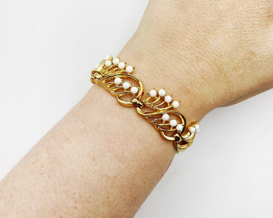Vintage Crown Trifari gold bracelet with white cabochons styled on wrist