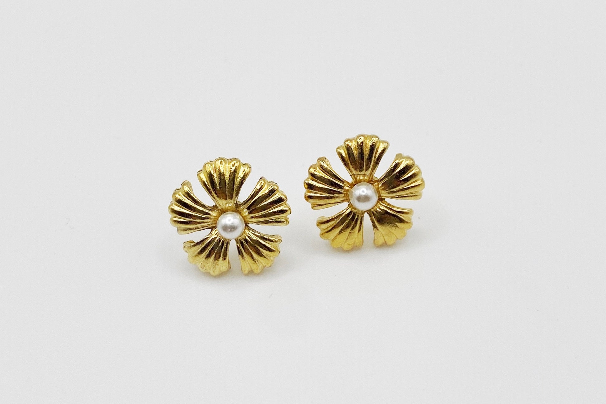 lose-up of 1990s Frayer vintage earrings showing faux pearl centre and textured 22kt gold plating. 