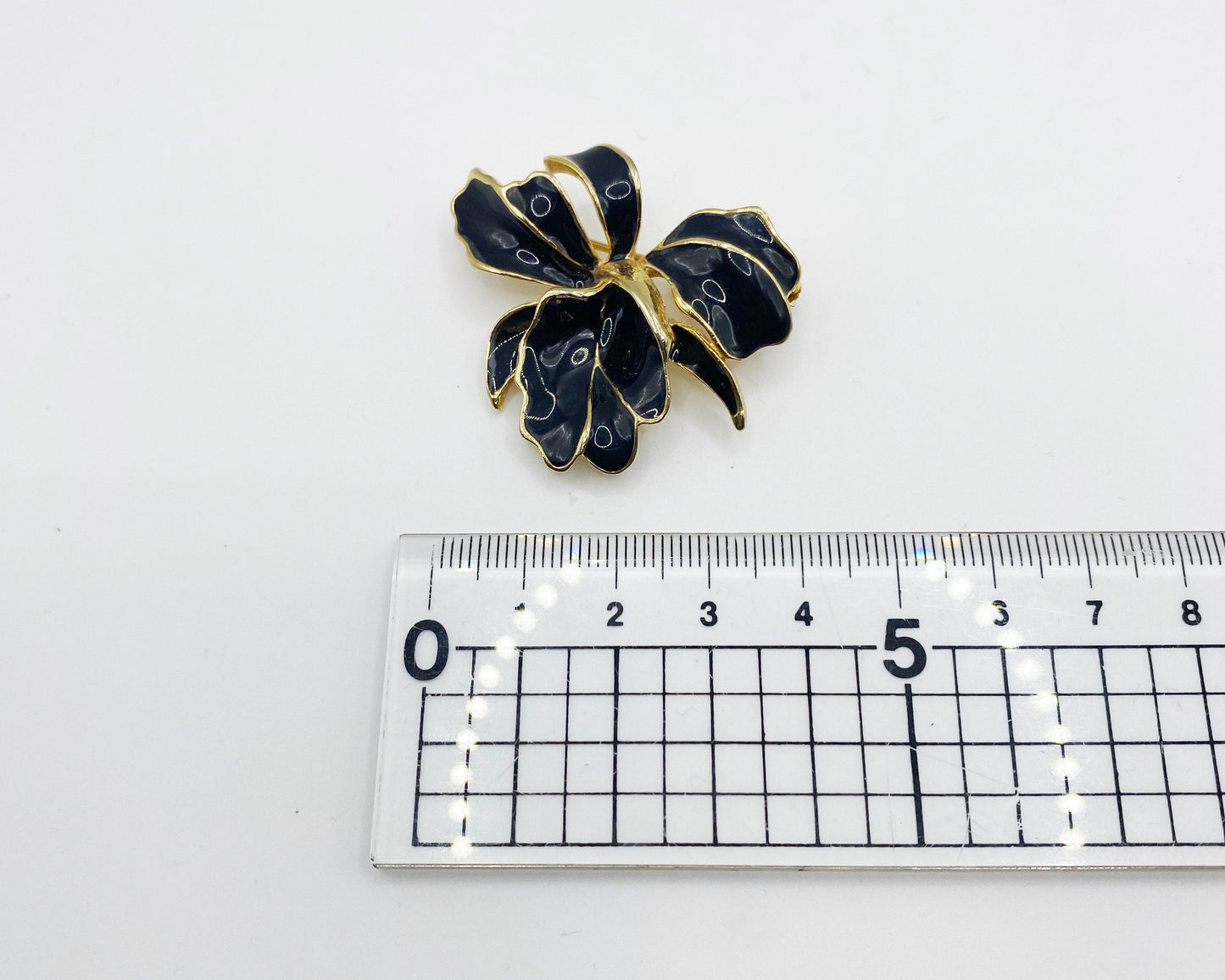 Measurement of vintage 1980s BARCS iris brooch in black enamel and gold plating