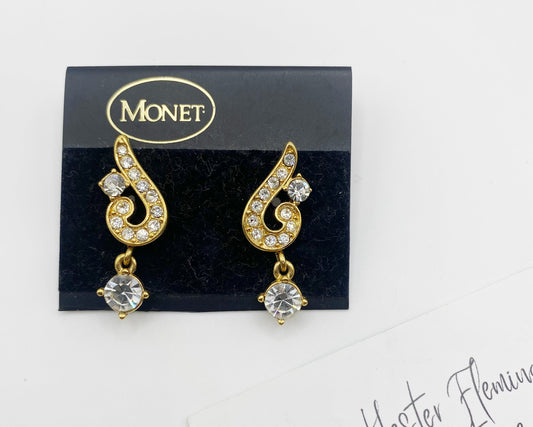 Front view of 1990s Monet gold-tone rhinestone swirl drop earrings on original card