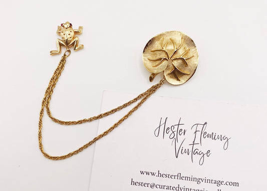 Rare vintage Trifari frog and lily pad brooch with gold plating and ruby crystal eyes.