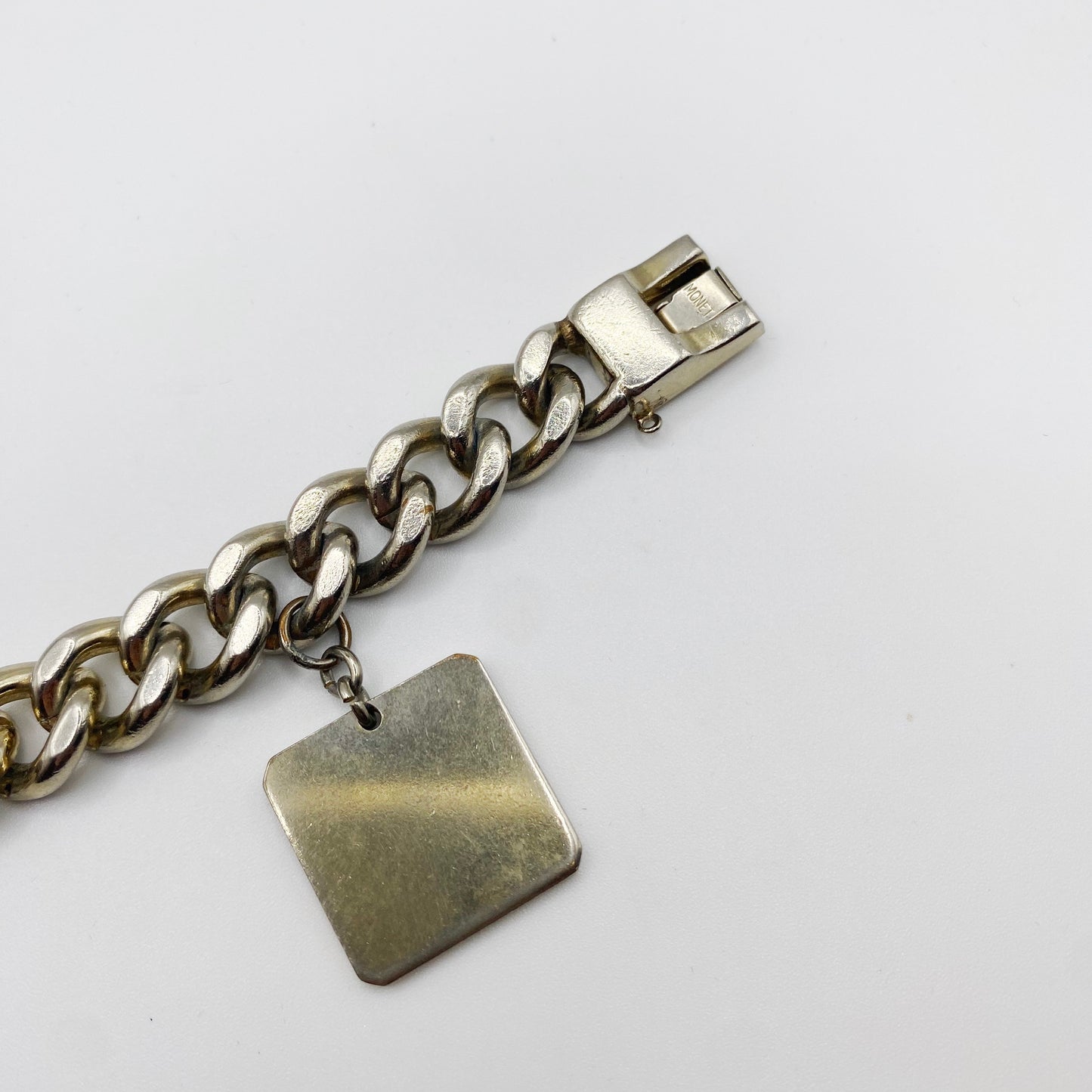 Close up of Monet Charm and Engraved Stamp of the Monet Signature. 