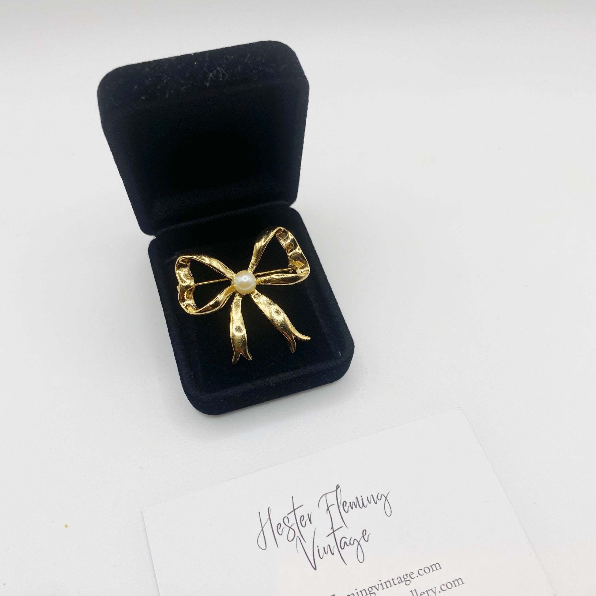 Elegant 80s–90s vintage brooch, gold-plated with pearl detail, shown on blazer. 