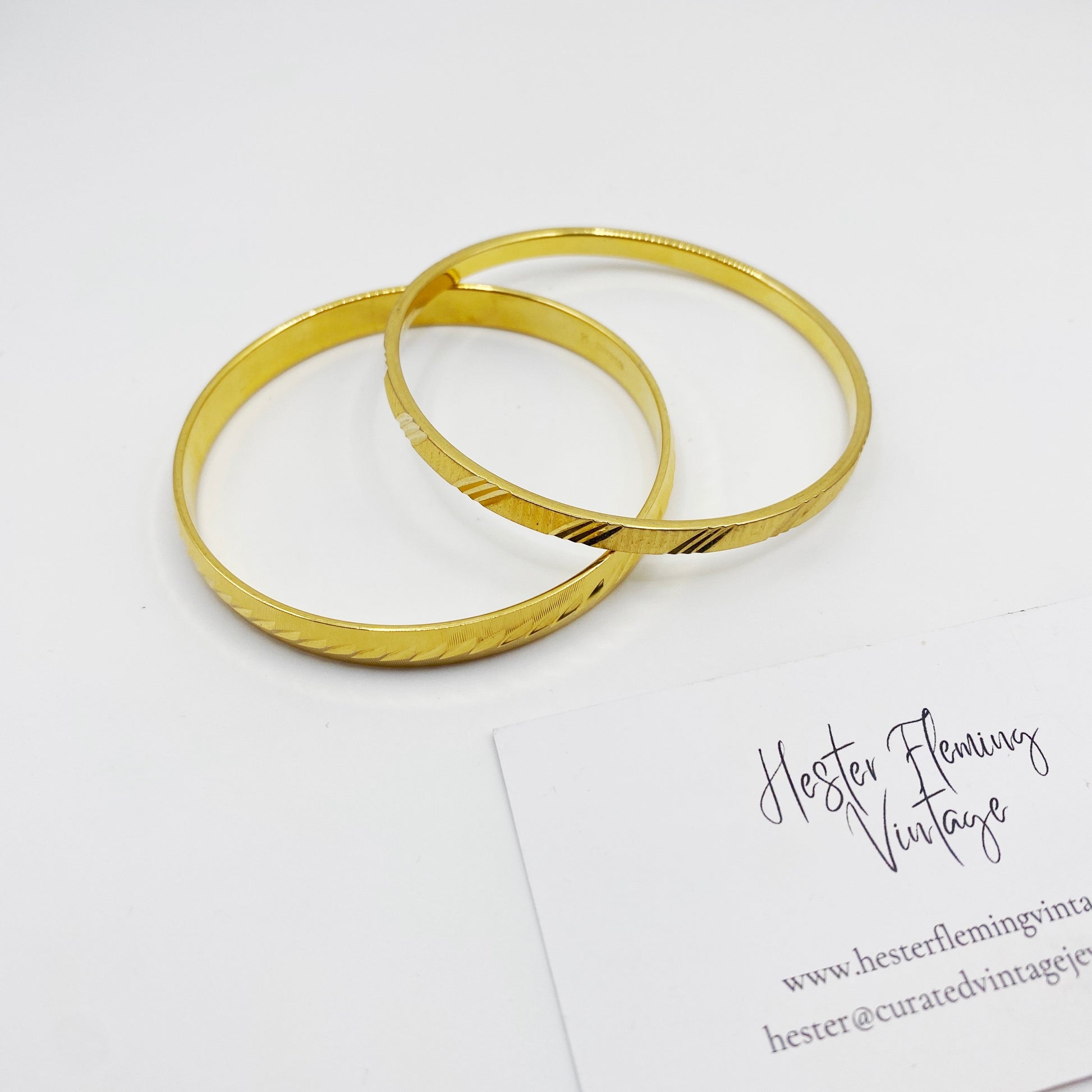 Pair of collectible gold-plated Monet bangles from the 1960s, classic mid-century design