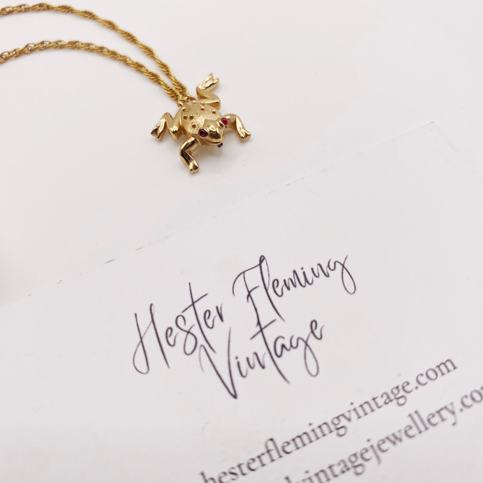Close-up of signed Trifari frog charm attached to a double chain. 