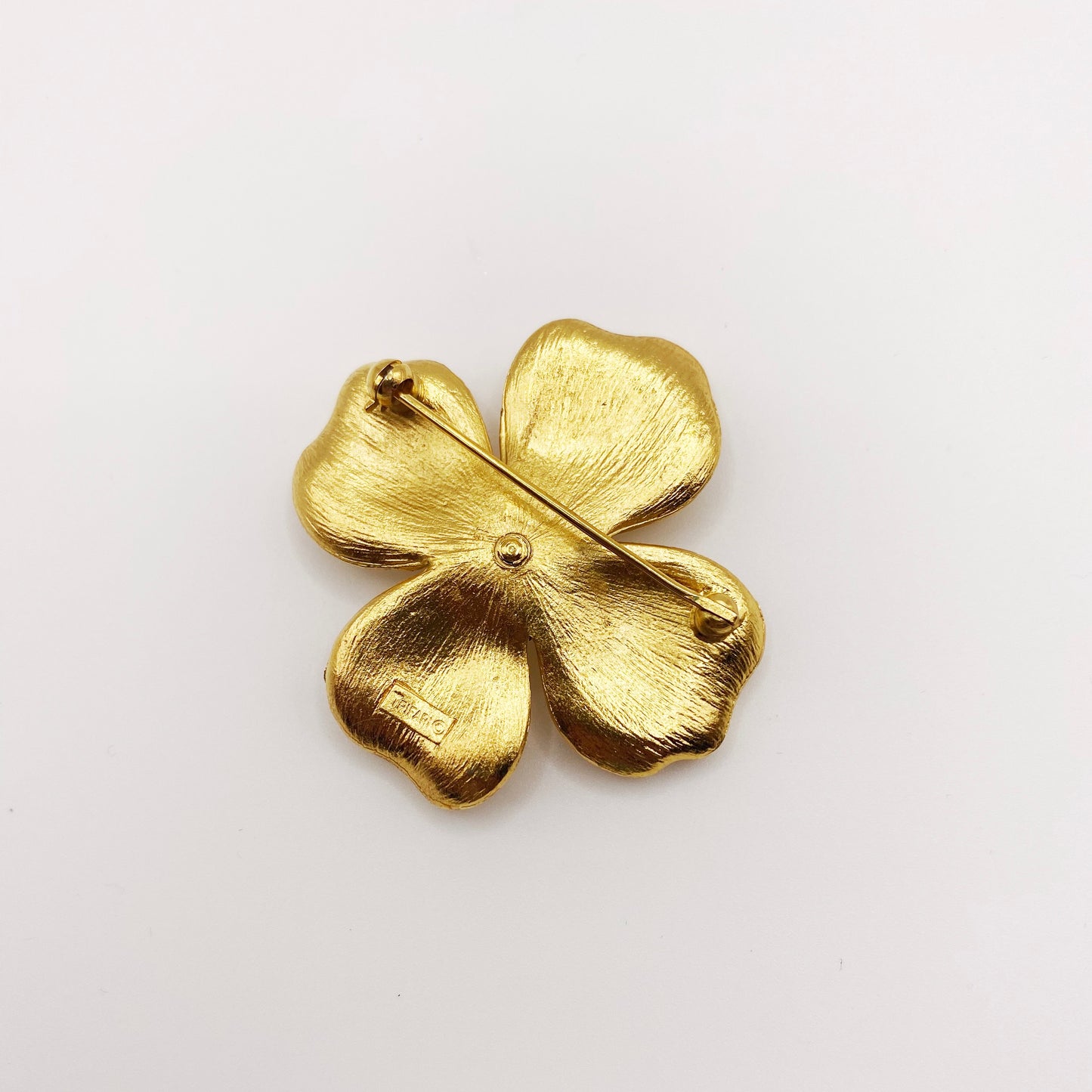 Back of vintage Trifari signed gold flower brooch with clasp detail.