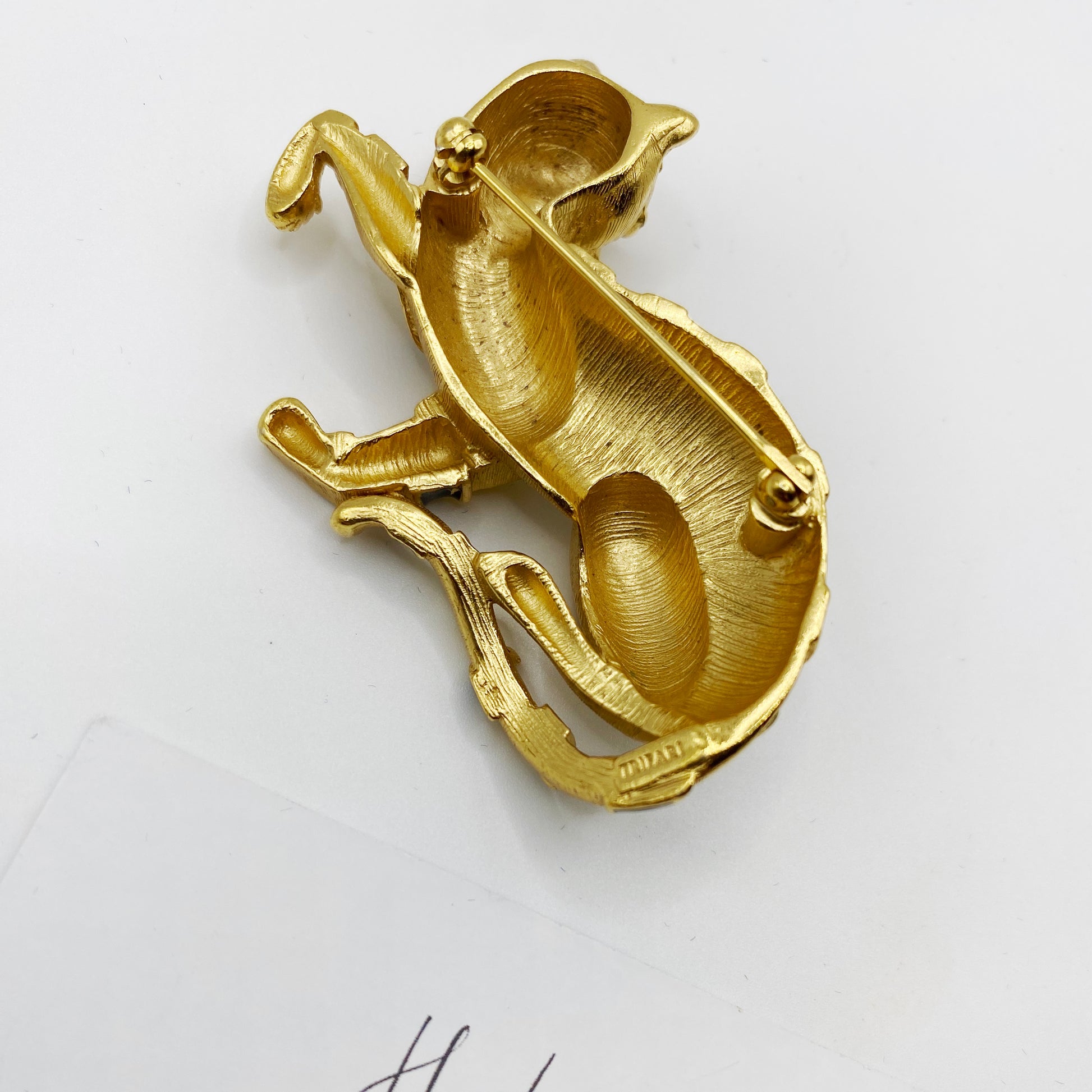 Back of vintage Trifari tiger brooch showing rollover clasp and signature