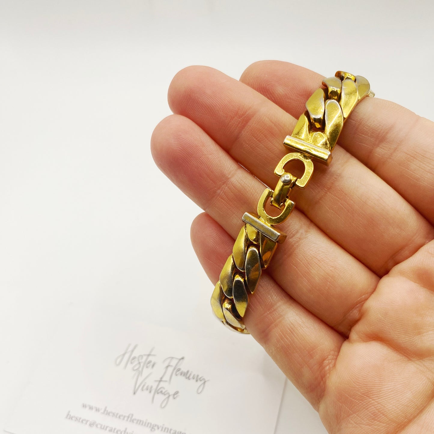 Close-up of the signature CD clasp on a 1970s Christian Dior gold link bracelet.