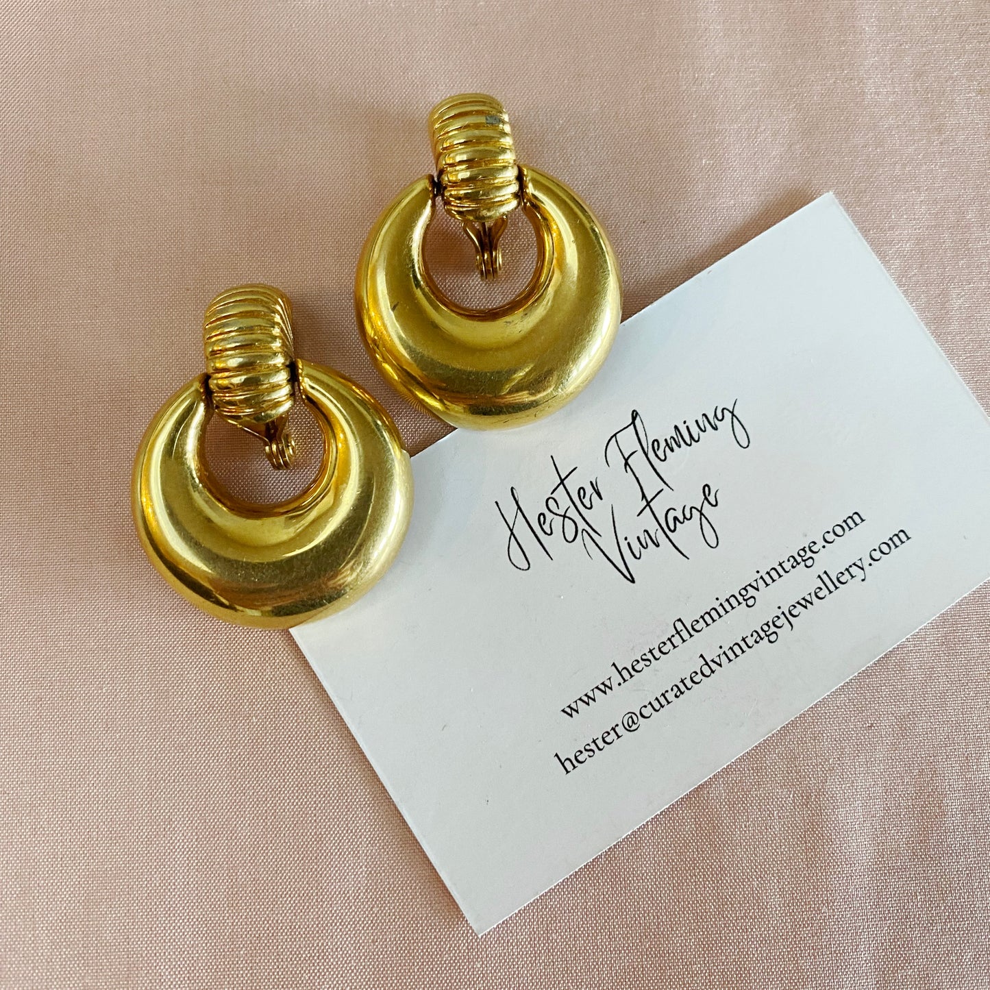 Front view of vintage 1970s Monet doorknocker earrings in gold plate, signed