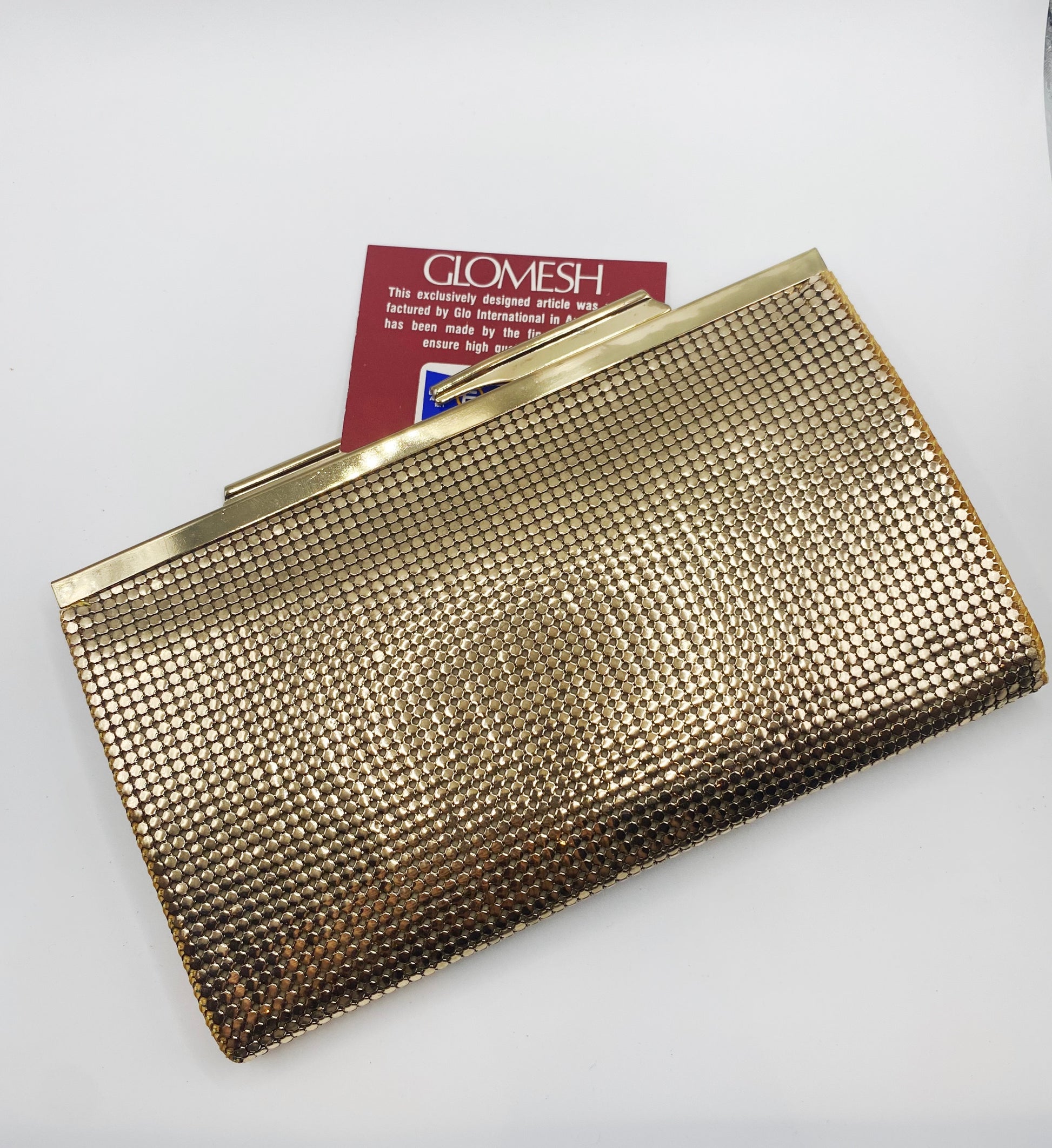 Close-up of gold mesh texture and Glomesh logo, 1977 vintage clutch.