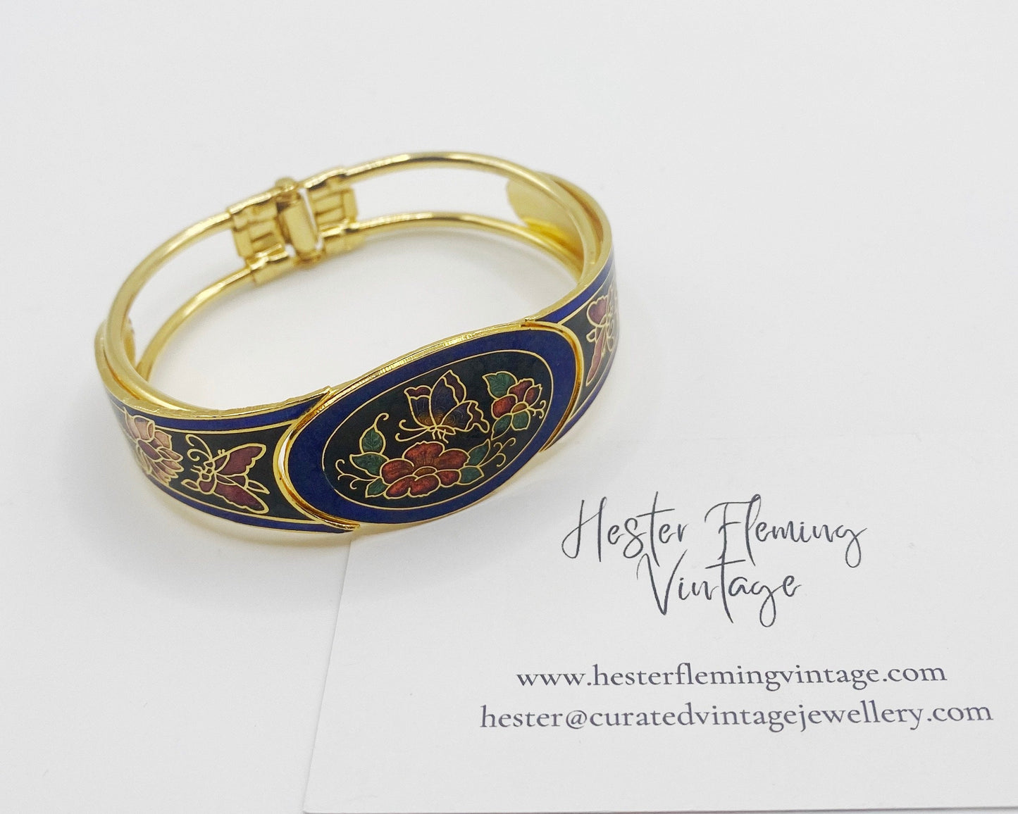 Front view of vintage 1980s cloisonné enamel bangle in blue and black with pretty butterfly and floral design