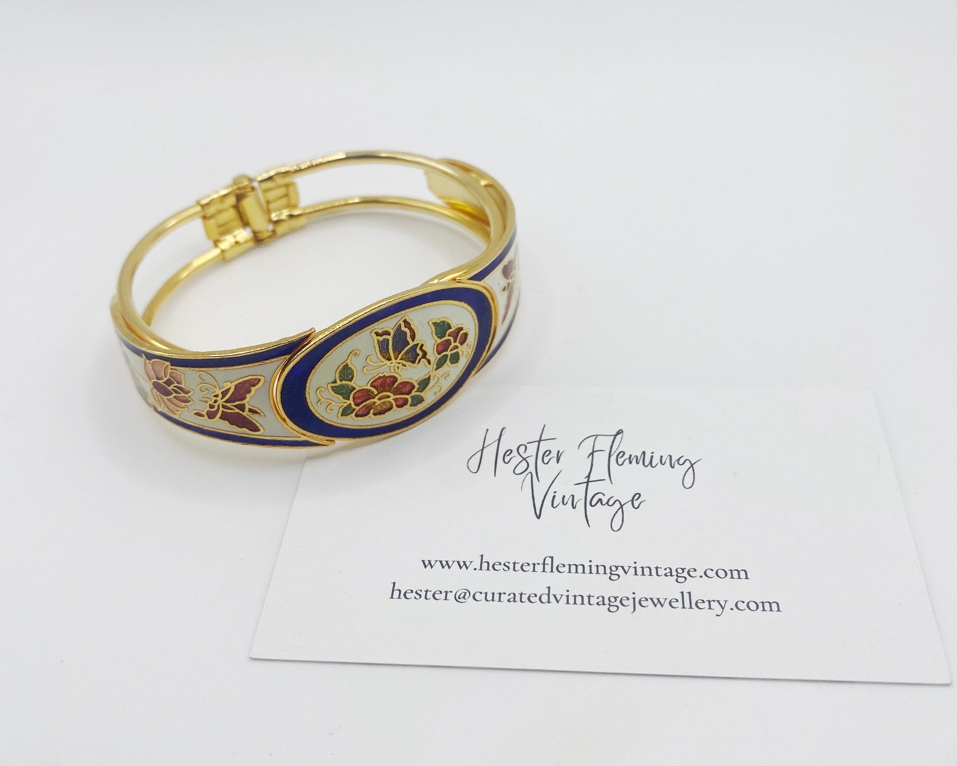 Front view of vintage 1980s cloisonné enamel bangle in white and blue with butterfly and floral design