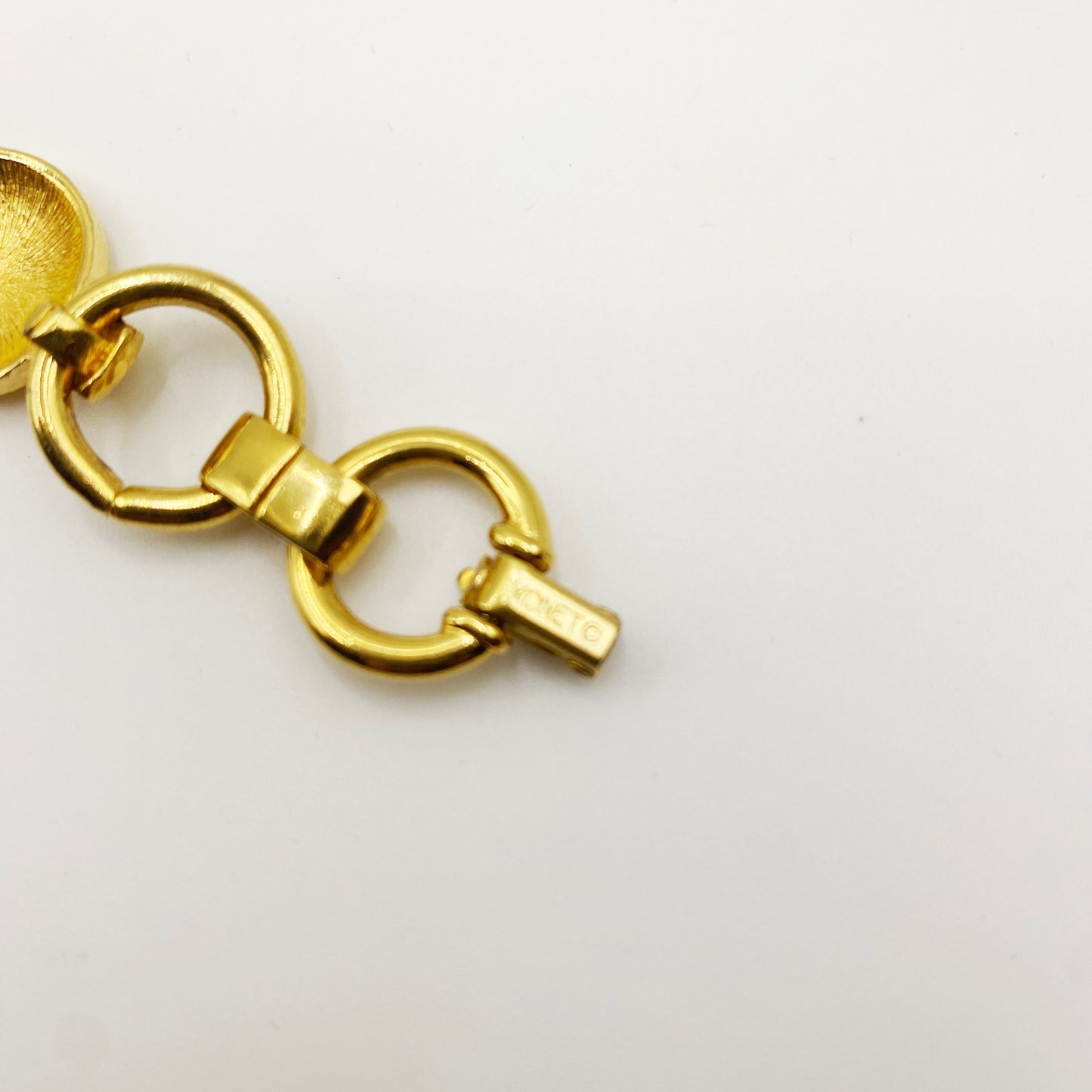 Close-up of signed Monet clasp on 1980s gold-plated bracelet