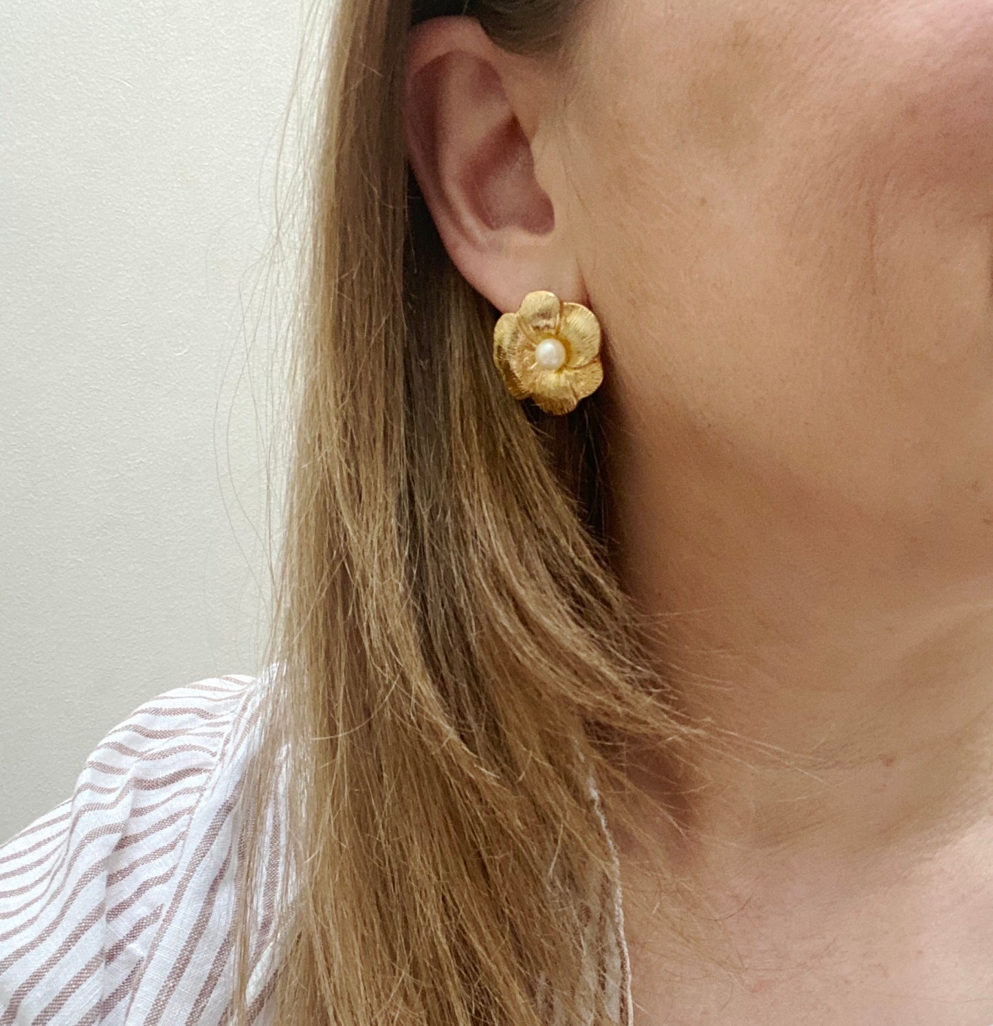 : Vintage 1990s gold and faux pearl earrings for pierced ears on model.