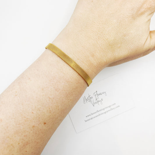 Vintage 1970s gold mesh bracelet worn on wrist