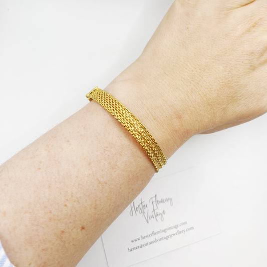 Vintage 1970s gold mesh bracelet on wrist.